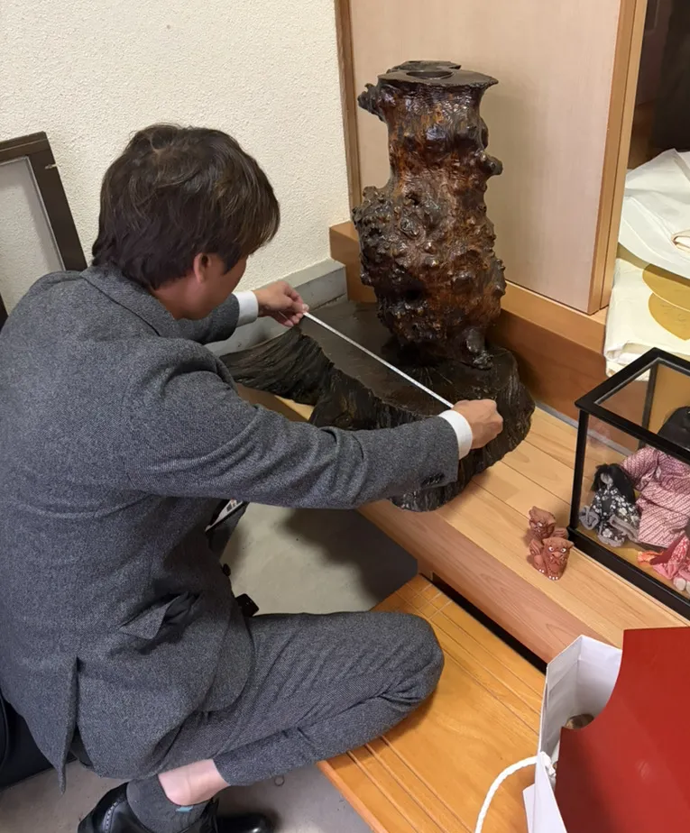 蔵から出てきた花台を採寸する査定士